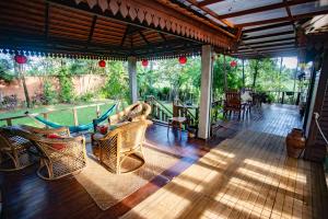 a screened in porch with chairs and a table at Khmer Oasis on the Lake 