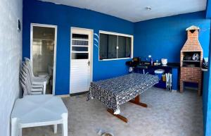 um quarto azul com uma mesa e uma cadeira em Casa temporada em peruibe em Peruíbe