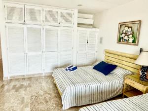 a bedroom with a bed with white shutters at Beach & Ocean Front Apartments Brisas Cancun Zona Hotelera in Cancún