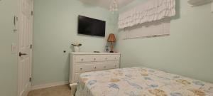 um quarto com uma cama e uma televisão na parede em The Salty Cove IRB em Clearwater Beach