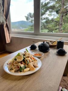een tafel met een bord eten op een tafel bij Belle House Đà Lạt in Da Lat