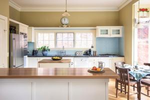 a kitchen with a table and a clock on the wall at Sassafras village stay - historic home sleeps 4 in Sassafras