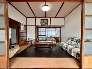 Wakamatsuにあるゲストハウス アイランドのリビングルーム(ソファ2台、テーブル付)