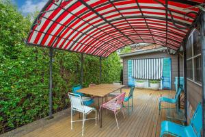patio con tavolo e sedie sotto una tettoia rossa di Bluebird Cottage a West Tamworth