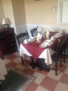a dining room table with a red and white table cloth at Atlantic House in Lisdoonvarna
