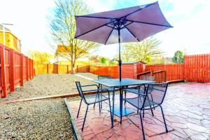 a table with two chairs and an umbrella at Millway Apartments Newcastle Gateshead with Free Parking in Sheriff Hill