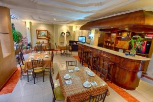 a restaurant with tables and chairs and a bar at Hotel Rio Piedra in Cuenca