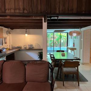 eine Küche und ein Wohnzimmer mit einem Sofa und einem Tisch in der Unterkunft Kutum's Wooden House - Private Pool, Breakfast & Cafe in Huma