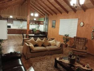 ein Wohnzimmer mit Couch und Küche in der Unterkunft Casa Cudico bajo- Lican ray in Villarrica