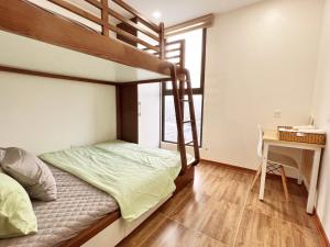 - une chambre avec des lits superposés et un bureau dans l'établissement Happy Homestay 3, à Lạng Sơn