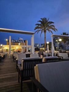 a restaurant with white tables and chairs on a deck at Lovely Apartament with a sunny terrace in Torrevieja