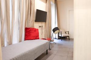 um quarto com uma cama com uma almofada vermelha e uma cadeira em Domus Superior Banchi Nuovi - Navona Pl. - Pantheon em Roma
