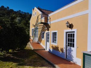 uma casa com uma escada que leva à porta da frente em Villa Rosa - Quinta do Santo Espírito em Aveiras de Baixo