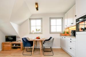 a kitchen with a table and chairs in a room at Oewern Diek App 13 in Wustrow