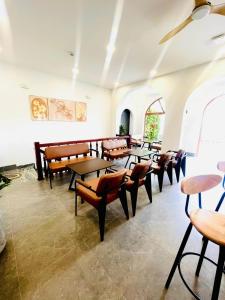 una fila de mesas y sillas en una habitación en Măng Đen Land - Homestay&Coffee en Kon Von Kla