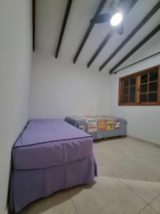 1 dormitorio con 1 cama de color púrpura en una habitación en Casa Amarela en Pirenópolis