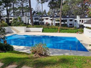a swimming pool in a yard with houses in the background at Villaggio Riviera in Punta del Este