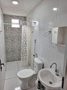 uma casa de banho branca com um WC e um lavatório em Casa em Pratigi, Universo Paralelo, Ituberá Ba. em Pratigi