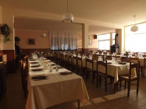 a large room with tables and chairs with white tablecloths at Albergo Ristorante Innocenti in Ardenno