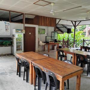 a group of wooden tables and chairs in a room at D'Bukit Forest in Pedas
