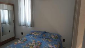 a bedroom with a bed with a blue comforter at Apartamento novo no Bessa in João Pessoa
