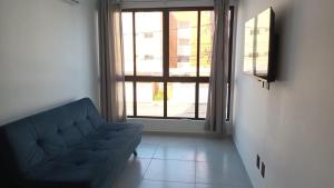 - un salon avec un canapé et une grande fenêtre dans l'établissement Apartamento novo no Bessa, à João Pessoa