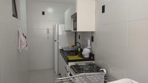 a kitchen with white cabinets and a refrigerator at Apartamento no NDM Bessa in João Pessoa