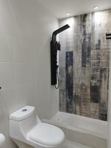 La salle de bains blanche est pourvue d'une douche et de toilettes. dans l'établissement Marejada, à Comodoro Rivadavia