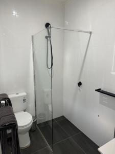 a bathroom with a toilet and a glass shower stall at Away on Blende Studio Loft in Broken Hill