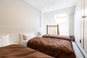 a bedroom with two beds and a window at コンドミニアム白馬五竜 in Hakuba