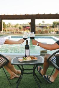 duas pessoas sentadas à volta de uma mesa com copos de vinho em Sol del Valle Cabaña 1 em Valle de Guadalupe