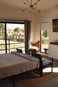 um quarto principal com uma cama e uma varanda em Sol del Valle Cabaña 1 em Valle de Guadalupe