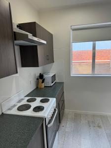 a kitchen with a white stove and a window at Away on Blende Studio Loft in Broken Hill