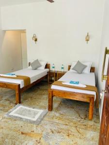 1 dormitorio con 2 camas y espejo en SALT LIFE MARARI BEACH VILLA, en Mararikulam