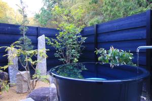 a large blue tub with plants in it next to a fence at まんのう清流庵 in Manno