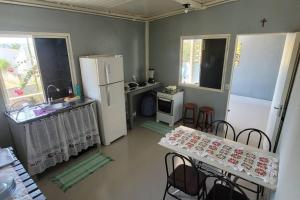 a kitchen with two tables and a white refrigerator at Casa Dom Aquino in Chapada dos Guimarães