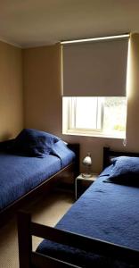 a bedroom with two beds and a window at Laguna Bahía, Algarrobo in Algarrobo