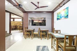 a dining room with tables and chairs and a ceiling fan at City Star Hotel & Restaurant in Jawāharnagar