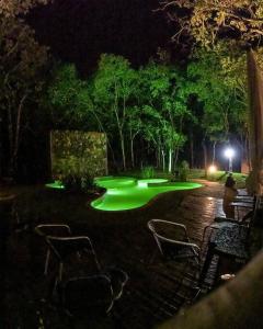 a pool with green lights in a yard at night at Sítio Quinta da Mata Chalé Amarelo in Pirenópolis