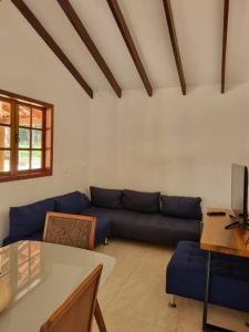 uma sala de estar com um sofá azul e uma mesa em Sítio Quinta da Mata Chalé Amarelo em Pirenópolis