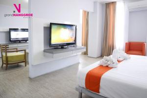 a hotel room with a television and a bed at Hotel Grand Nanggroe in Banda Aceh
