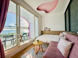 a bedroom with a bed and a large window at 南灣陽光皮小妞 Pii hostel in Nanwan