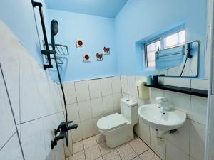 a bathroom with a white toilet and a sink at 南灣陽光皮小妞 Pii hostel in Nanwan
