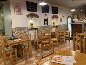 una sala da pranzo con tavoli e sedie in legno di Penzion Verde Rosa a Harrachov