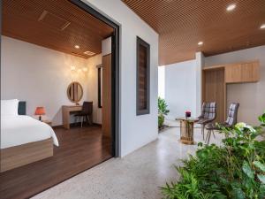 um quarto com uma cama e uma secretária com cadeiras em MoonLight Tay Ho em Hanói