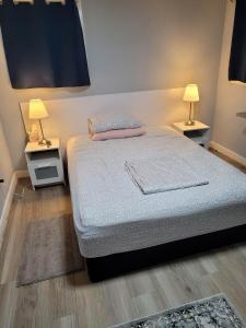 a bedroom with a bed with two night stands and two lamps at The Dune Beach House in Norfolk