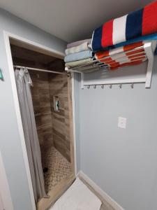 a walk in shower in a bathroom with a closet at The Dune Beach House in Norfolk +25 photos