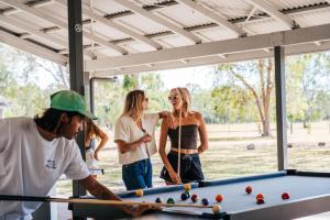 a group of people standing around a pool table at Kangarooms Noosa Everglades in Cootharaba