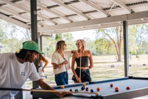 a group of people standing around a pool table at KangaROOMS Noosa Everglades YHA in Cootharaba
