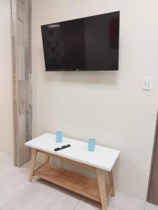 - Mesa de centro blanca con TV de pantalla plana en la pared en Marejada en Comodoro Rivadavia